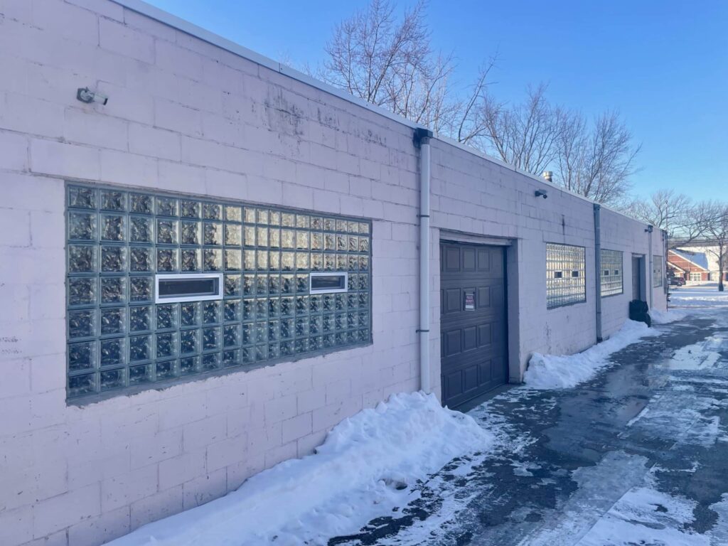 Glass block windows with vents on snow-covered commercial building